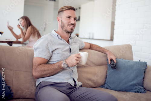 Man relaxing with coffee and television.