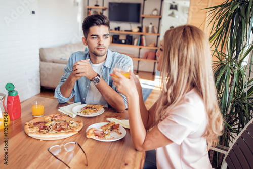 Couple enjoying a large pizza at home on a date