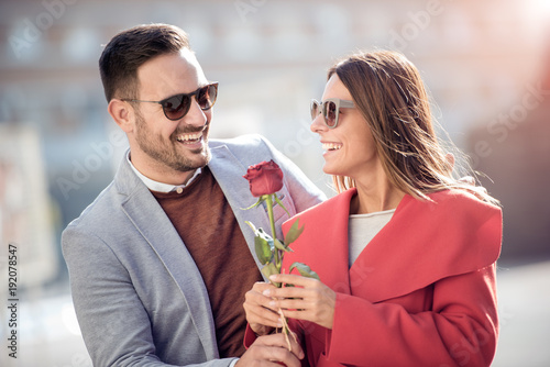Man giving woman a rose.