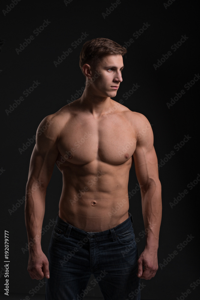 man with a sporty physique in the studio on a black background man with a sporty physique in the studio on a black background