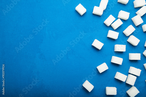 Sugar refined cubes on a blue background. Copy space.