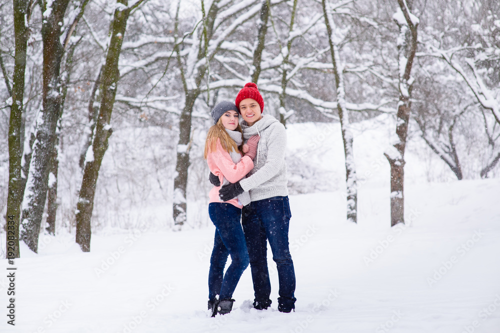 Young couple in hugs in snow forest