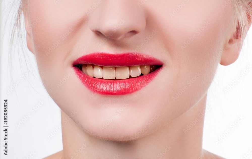 Fototapeta premium White teeth and red lips. Perfect female smile after whitening teeth.