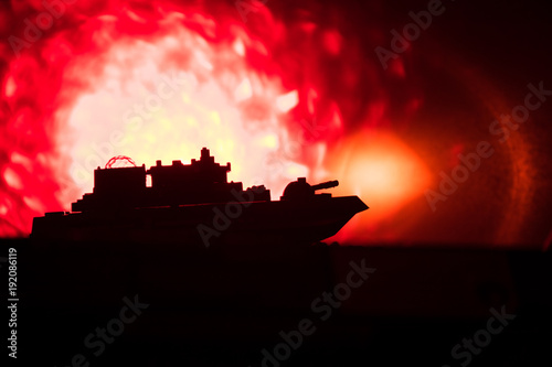 Silhouette of military war ship on dark foggy toned sky background. Selective focus