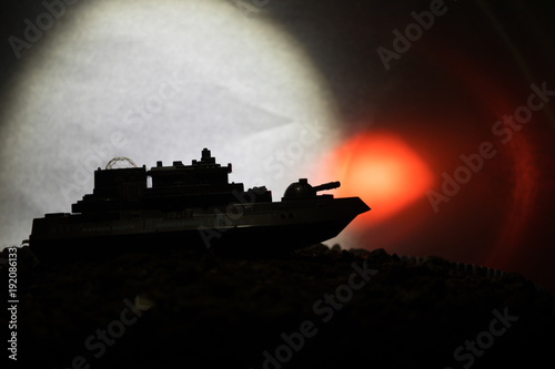 Silhouette of military war ship on dark foggy toned sky background. Selective focus