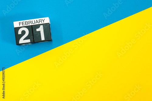 February 21st. Day 21 of february month, calendar on blue and yellow background flat lay, top view. Winter time. Empty space for text