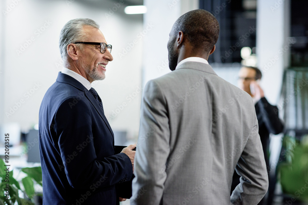 selective focus of multicultural businessmen having conversation in office