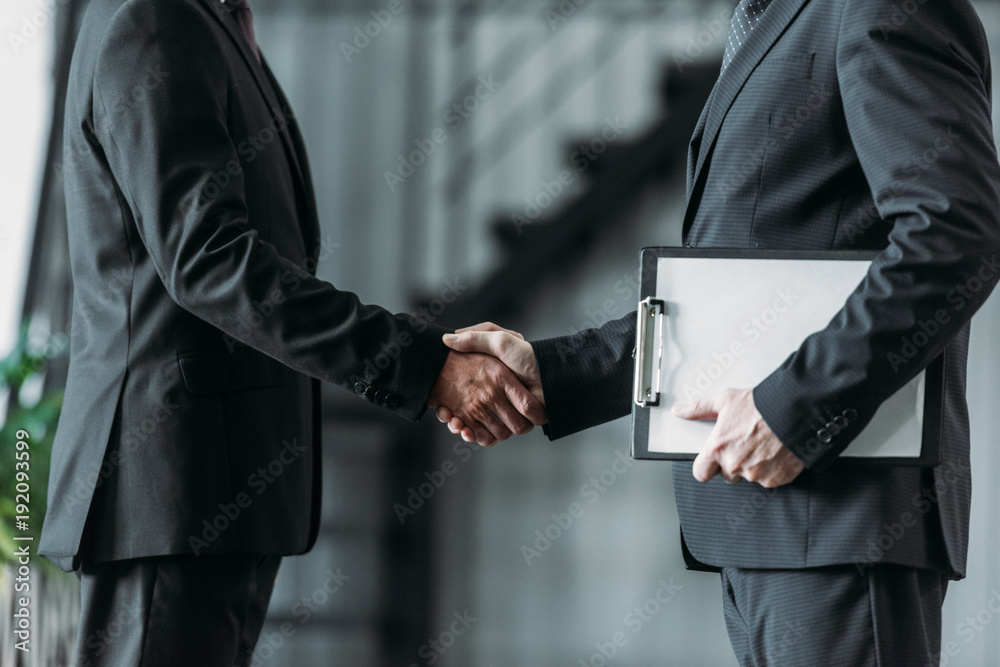 partial view of businessmen shaking hands