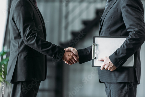 partial view of businessmen shaking hands