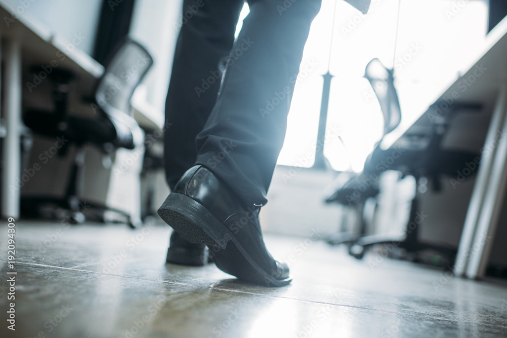 partial view of businessman walking in office