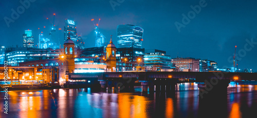 panorama of modern london cityscape in the night with Southwark Bridge in the foreground