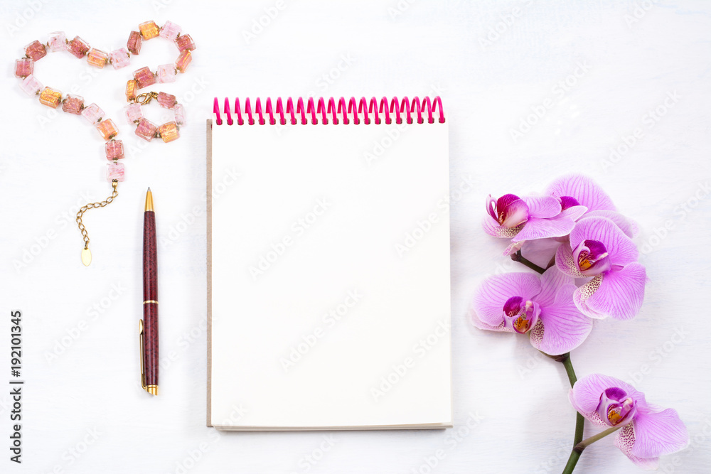 Mockup with notepad, pen and pink orchid, top view Mockup with notepad, pen and pink orchid, top view