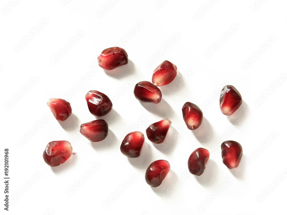 Close up of scattered group of pomegranate seeds isolated on white background - from above Close up of scattered group of pomegranate seeds isolated on white background - from above