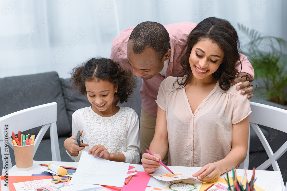 Fototapeta premium african american parents and daughter making greeting card