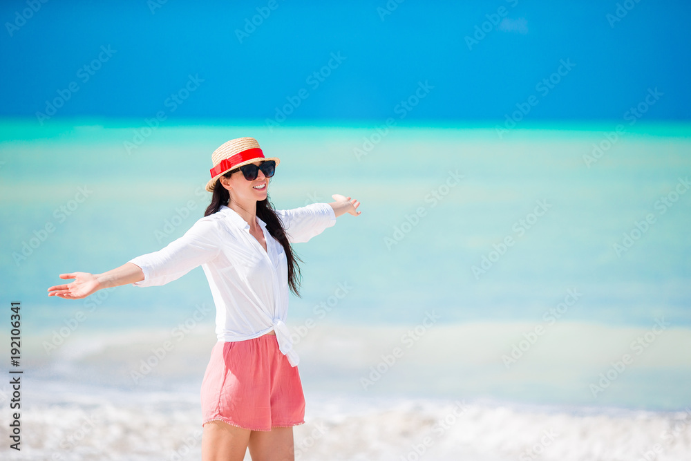 Young beautiful woman on white sand tropical beach. Caucasian girl with hat background the sea
