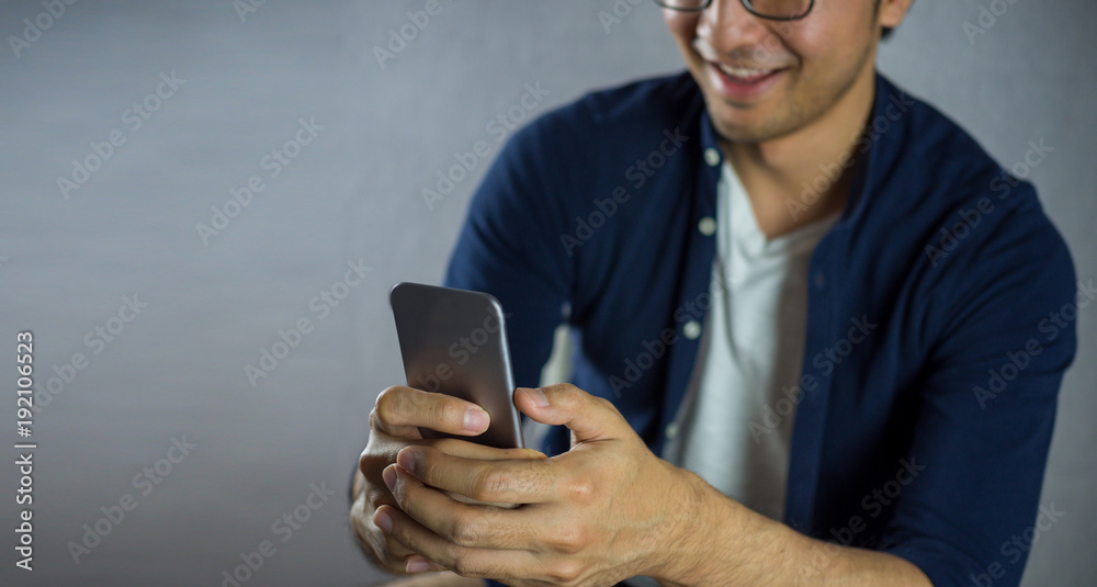 Men smiling using phone on grey background Men smiling using phone on grey background