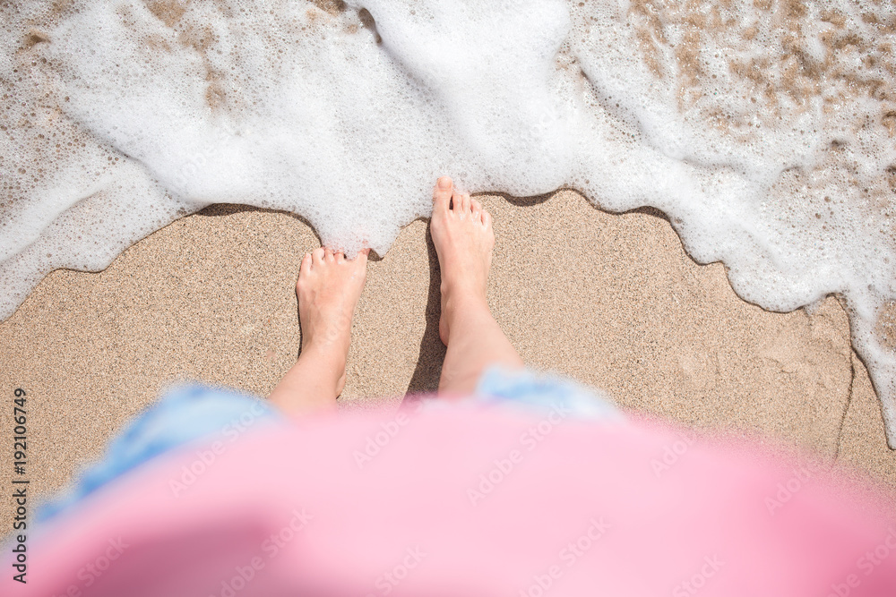Close up of young woman feet on a tropical sandy beach