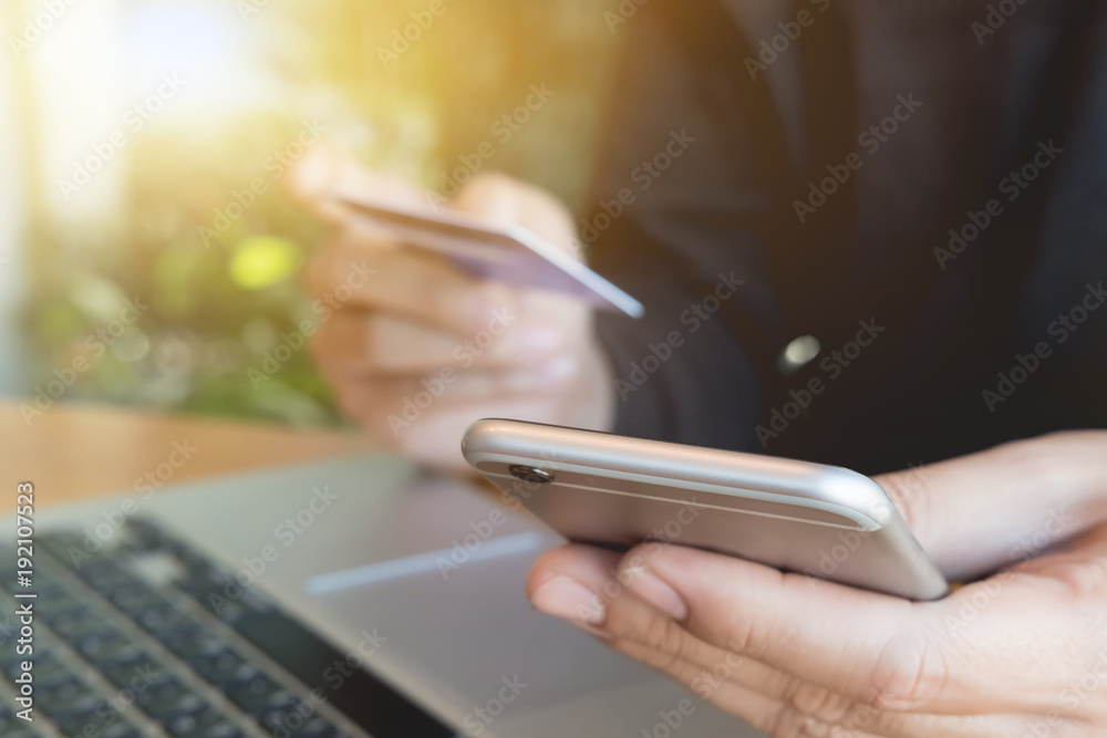 Online payment,Man's hands holding smartphone and using credit card for online shopping.