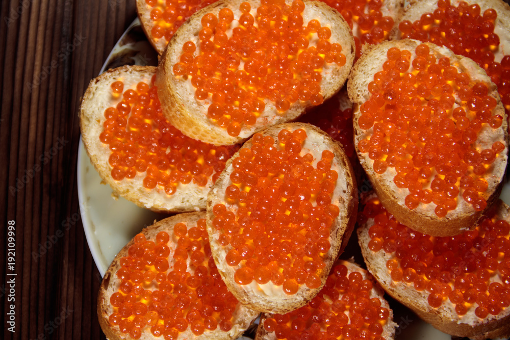 Sandwiches with butter and red caviar on wooden table Sandwiches with butter and red caviar on wooden table