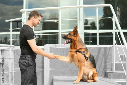 Security guard with dog near building photo