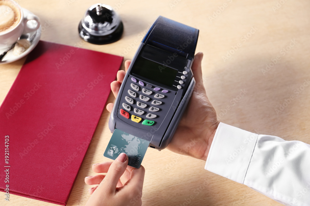 Waiter receiving payment by credit card at the restaurant, closeup Waiter receiving payment by credit card at the restaurant, closeup