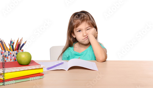 Bored little girl unwilling to do homework against white background