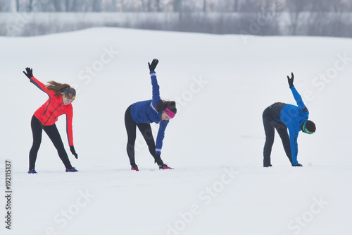 Group of athletes doing the exercise in winter field