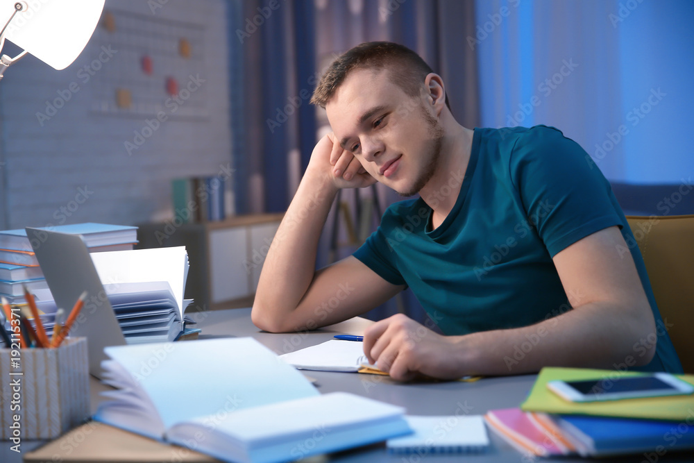 Student doing homework indoors late at night Student doing homework indoors late at night