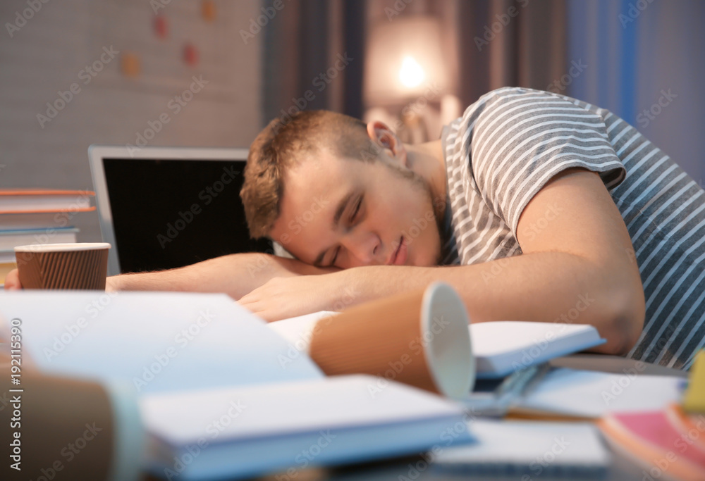 Tired student sleeping at table indoors Tired student sleeping at table indoors