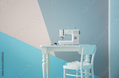 Sewing machine on table in tailor's workshop photo