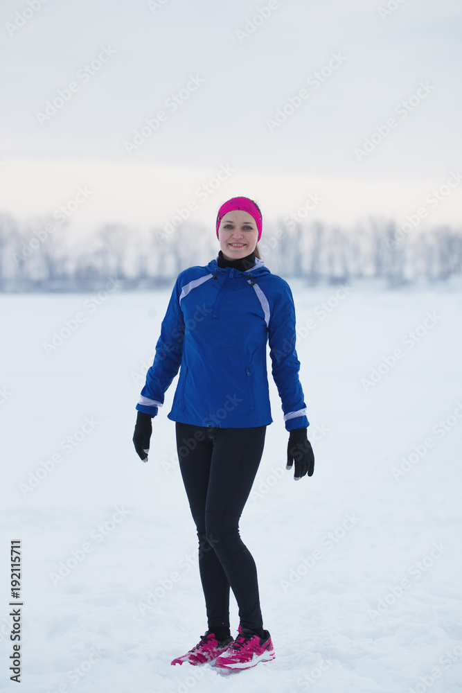 Portrait of a smiling young female sportswoman in winter ice river