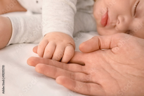 Sleeping baby holding mothe...