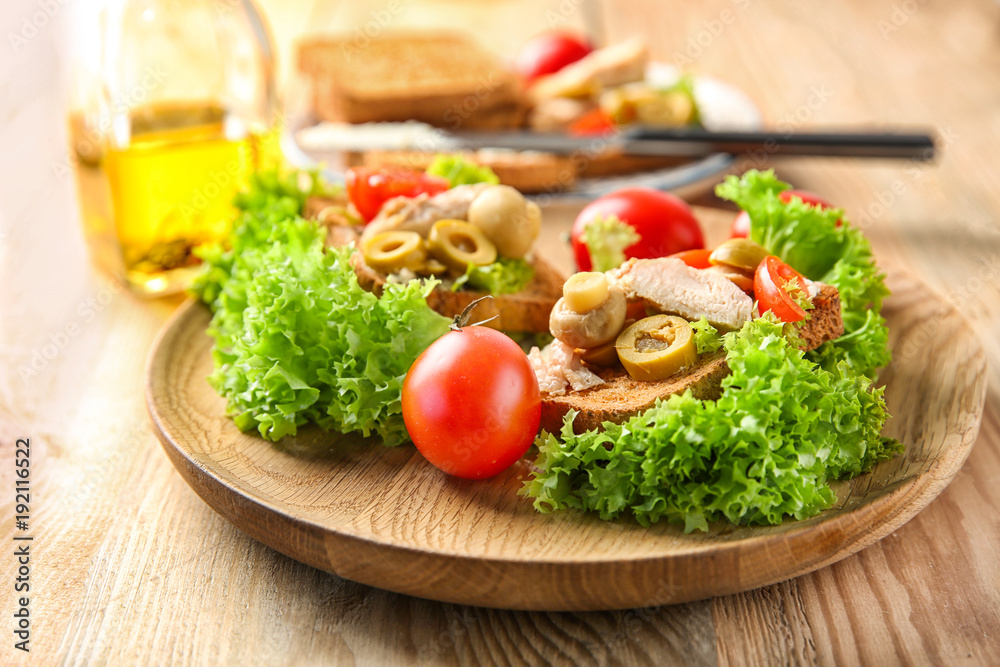 Plate with tasty chicken bruschettas on wooden table Plate with tasty chicken bruschettas on wooden table