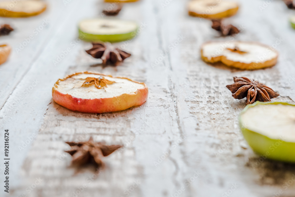 scattered slices of dried apples and star anise, on a wooden surface toned background decoration design scattered slices of dried apples and star anise, on a wooden surface toned background decoration design