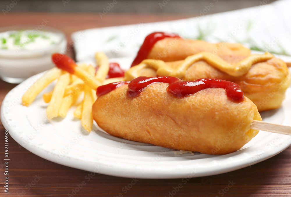 Tasty corn dogs with sauces on plate, closeup Tasty corn dogs with sauces on plate, closeup