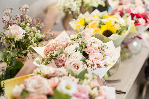 Bouquets on table, florist business. Different varieties fresh spring flowers. Delivery service. Flower shop concept.