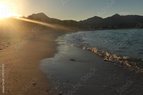 Sun Rays Catching the Waves on a Deserted Omani Beach at Sunset