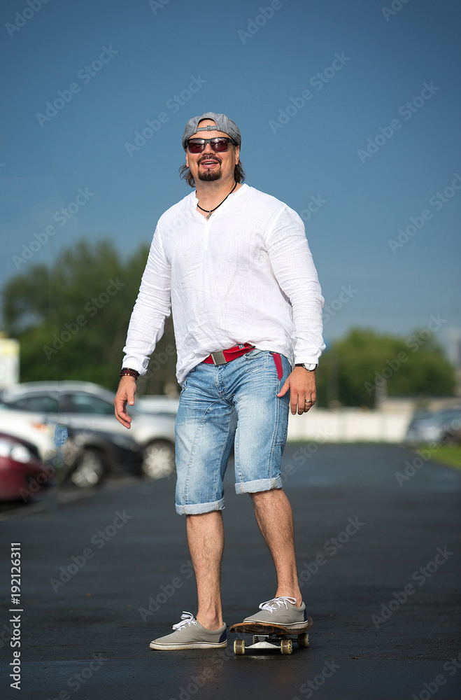 A man is riding a skateboard outside on a sunny day. Sport, movement, pleasure. A man is riding a skateboard outside on a sunny day. Sport, movement, pleasure.
