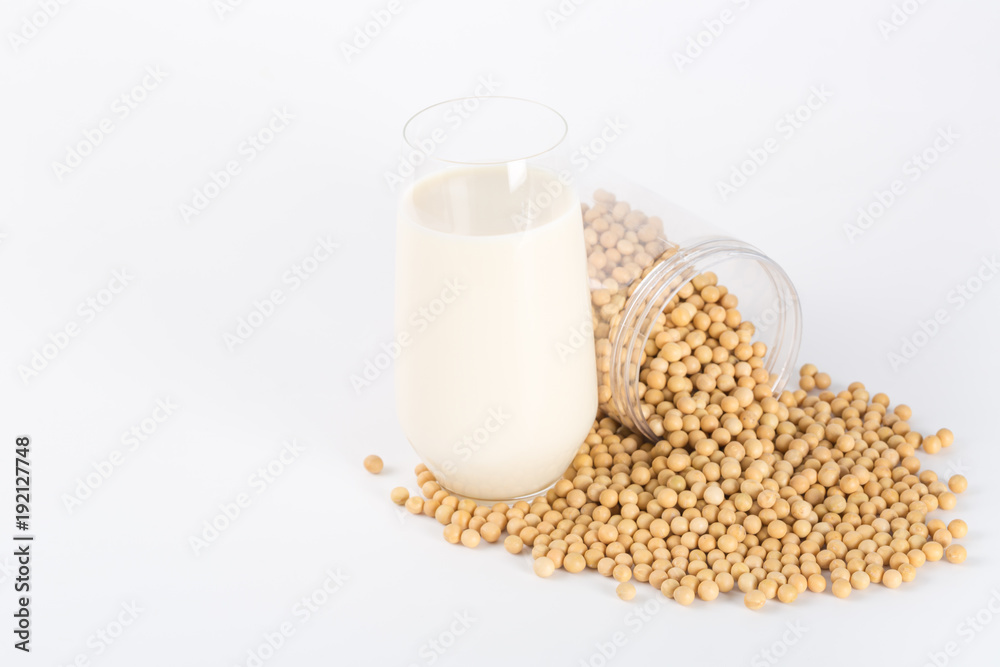 Soy milk in glass with soybeans on white background
