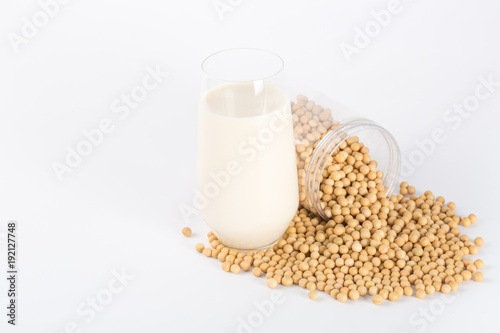 Soy milk in glass with soybeans on white background
