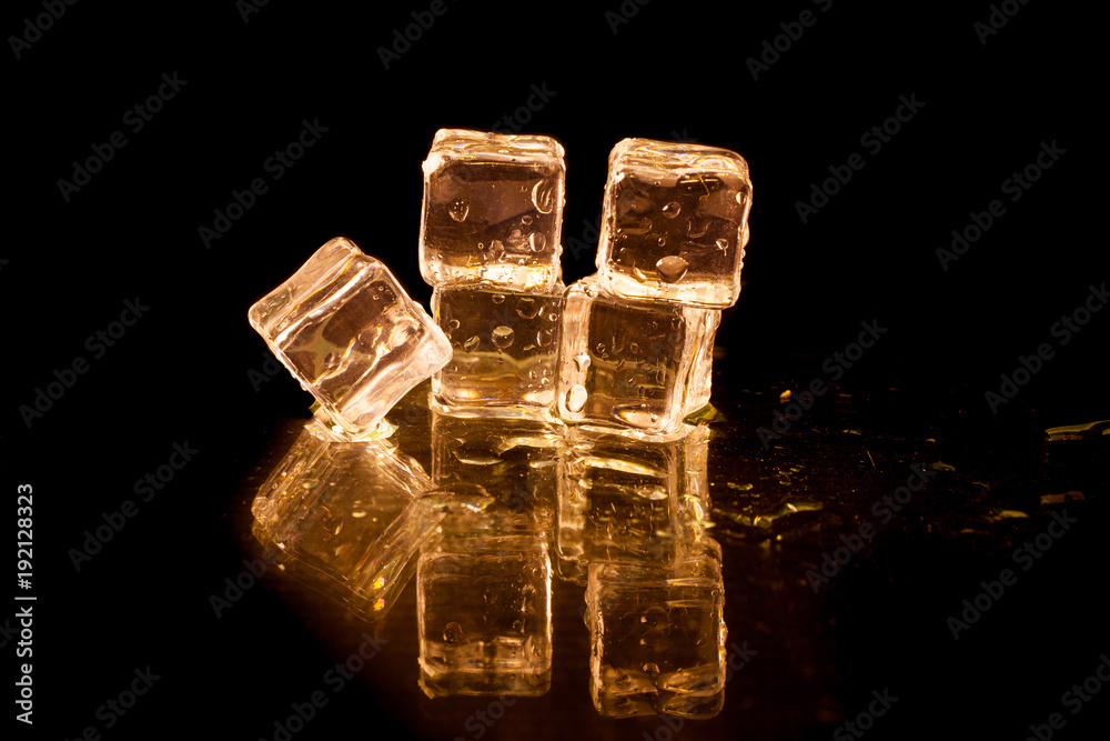 Gold ice cubes on black background. Photos | Adobe Stock