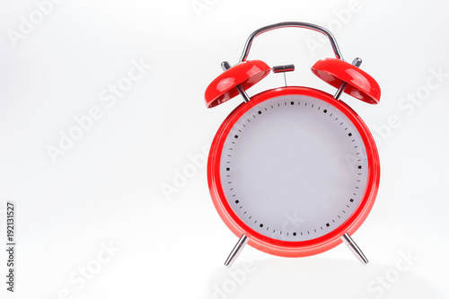 Old red retro alarm clock without numbers isolated on white background