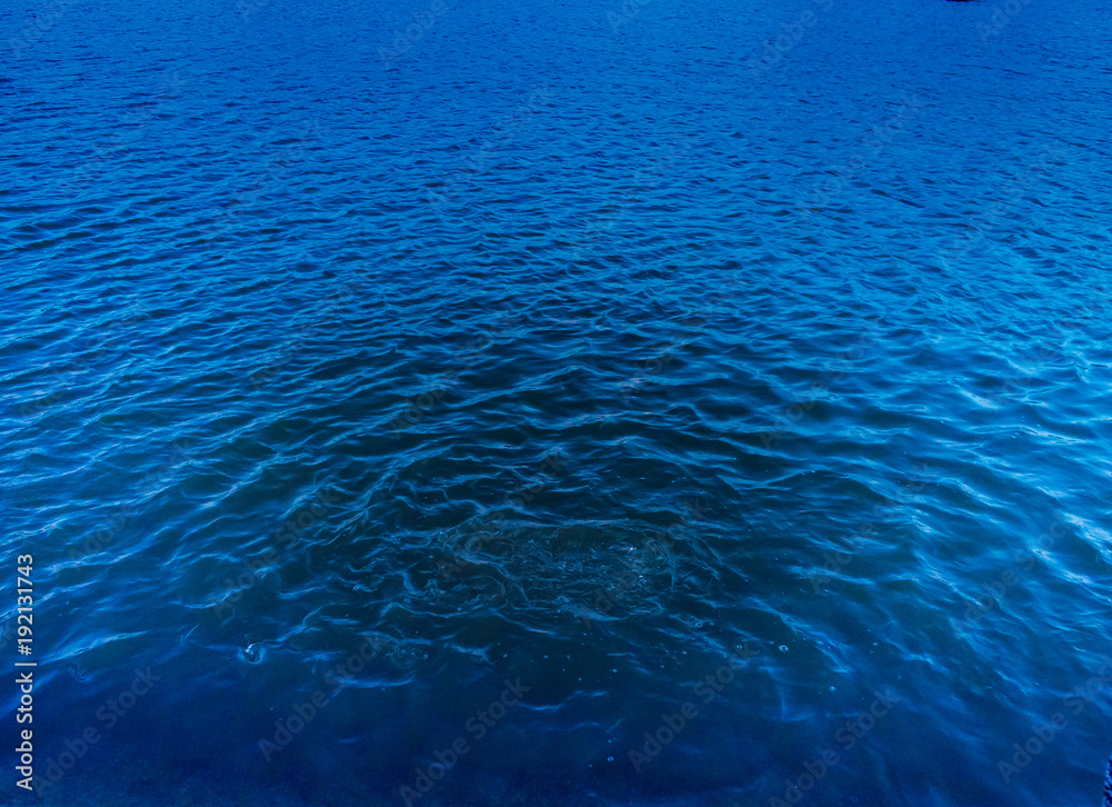 The surface of the lake is a small wave of birds flying through the sun near the horizon. The surface of the lake is a small wave of birds flying through the sun near the horizon.
