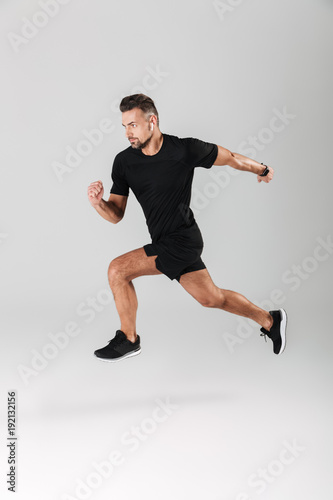 Full length portrait of a strong mature sportsman jumping