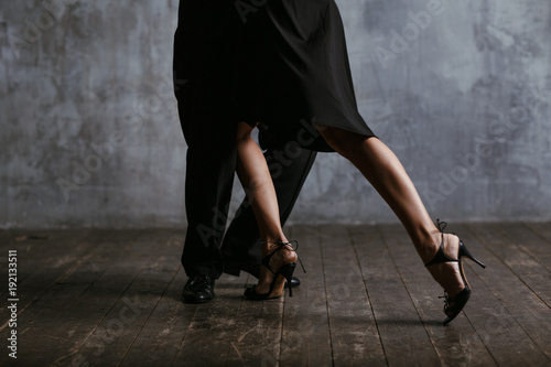 Young pretty woman in black dress and man dance tango photo