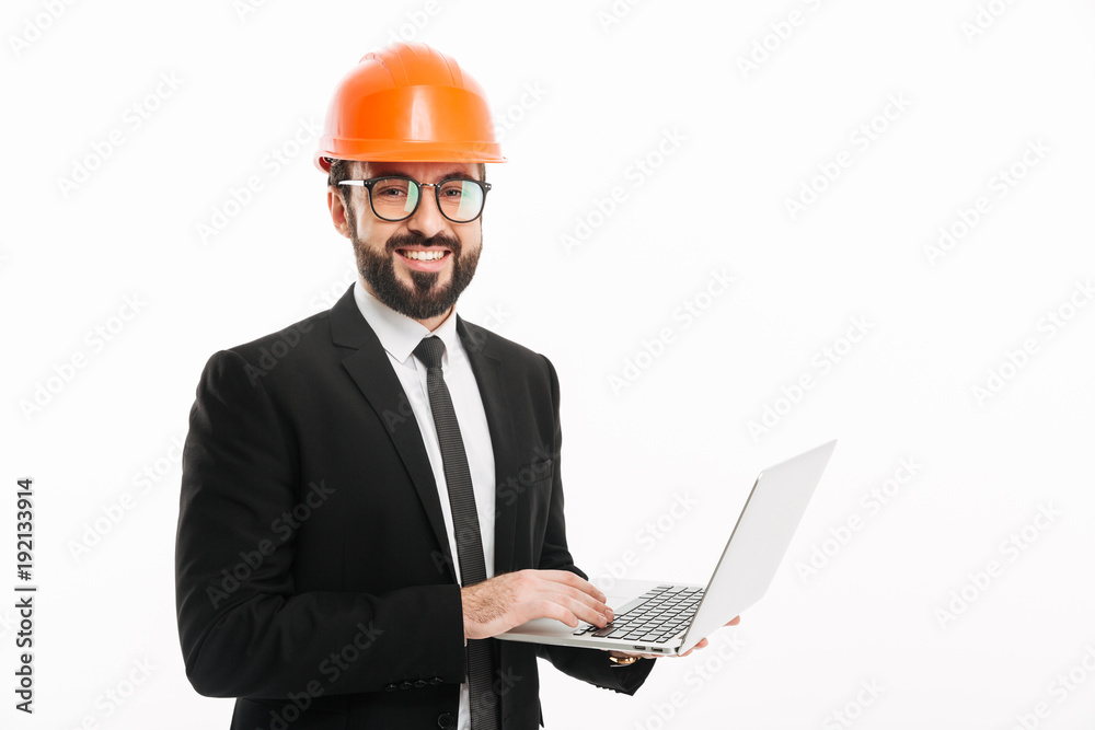 Happy builder engineer wearing helmet using laptop computer. Happy builder engineer wearing helmet using laptop computer.