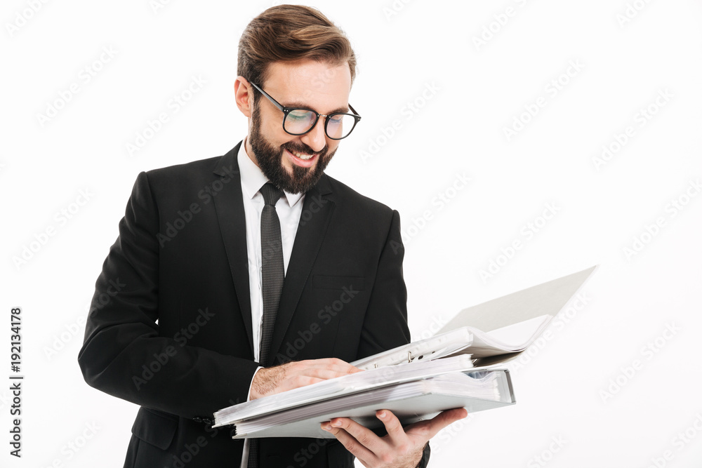 Cheerful young businessman reading documents in folders. Cheerful young businessman reading documents in folders.