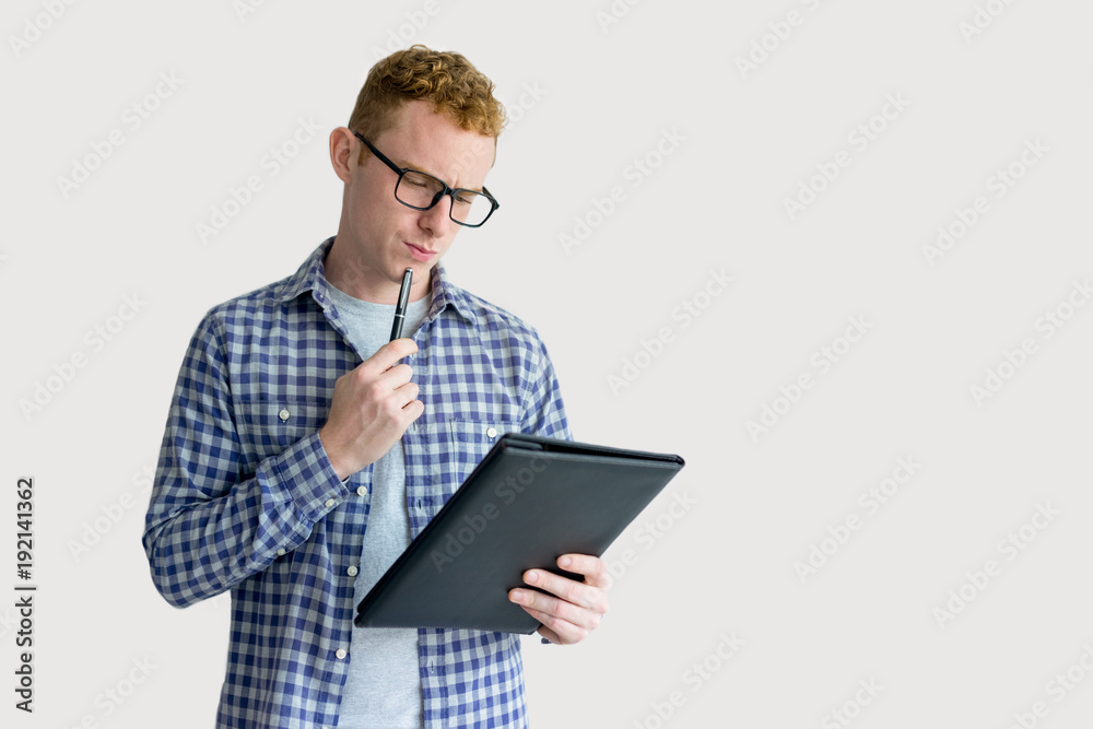 Pensive Red Haired Young Man Looking at Folder Pensive Red Haired Young Man Looking at Folder
