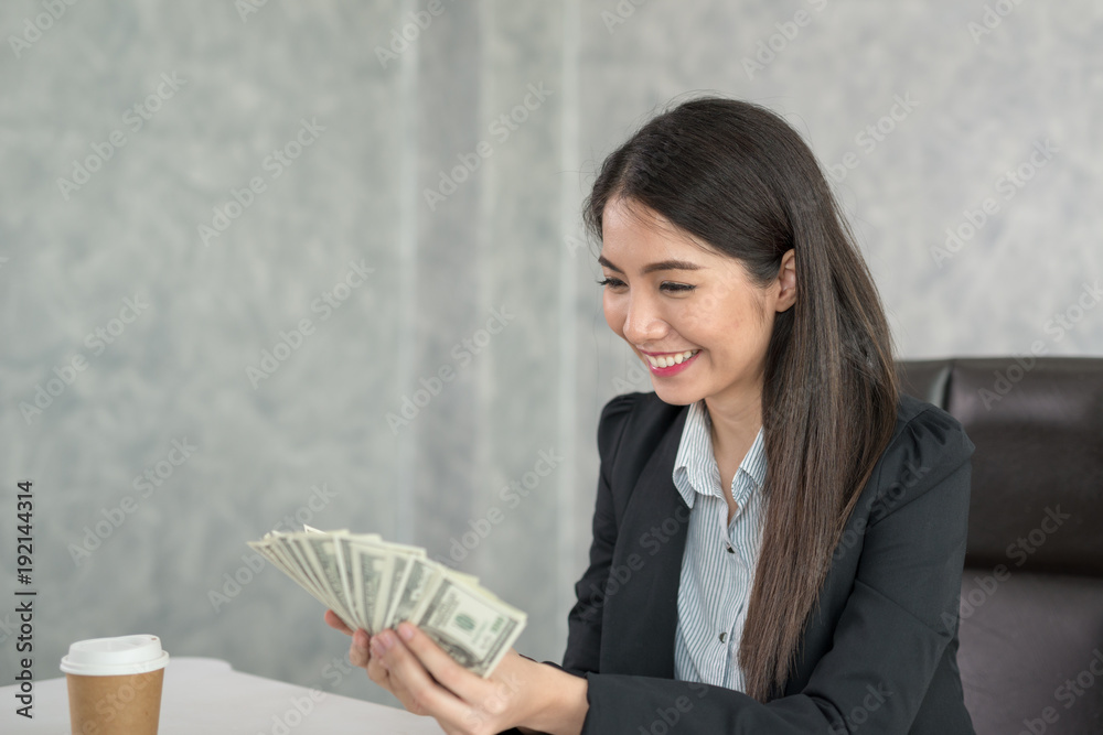 Asian business woman holding money in hand and smiling happy to business success. Asian business woman holding money in hand and smiling happy to business success.