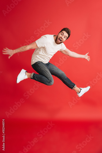 Excited emotional bearded man jumping
